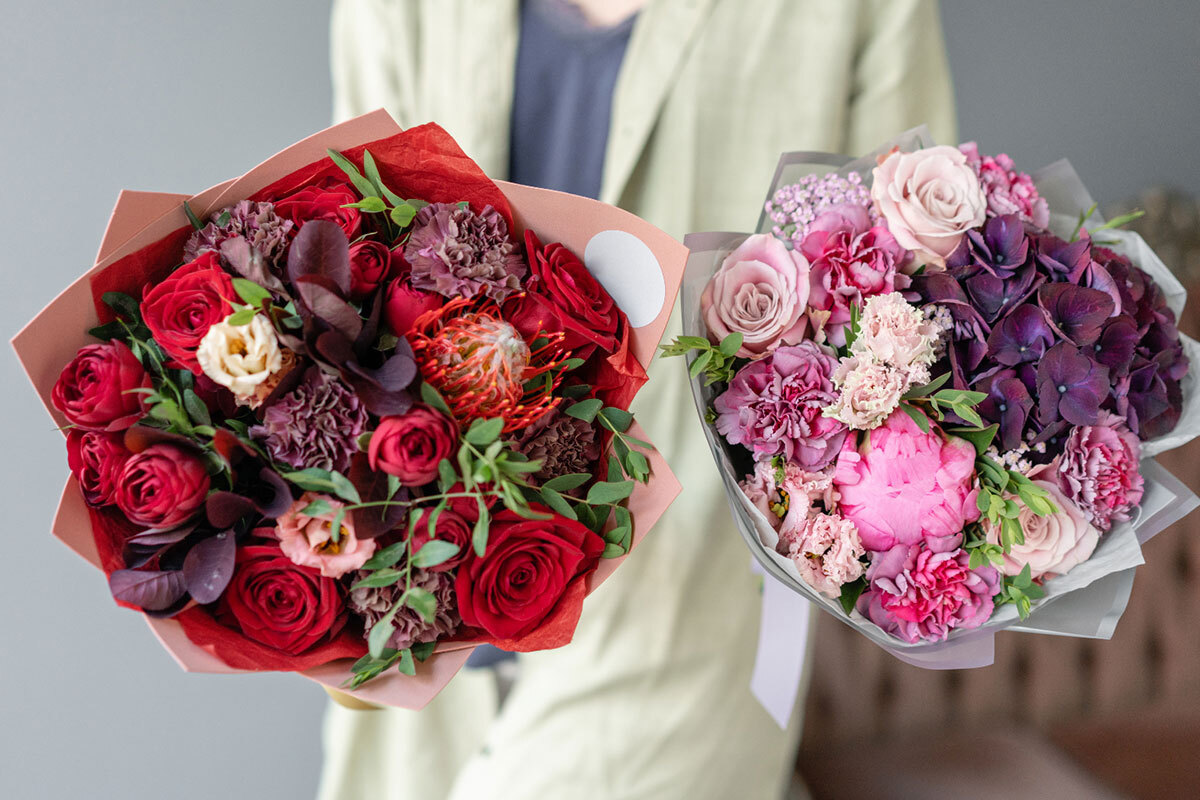 A young florist holding two beautiful bouquets.