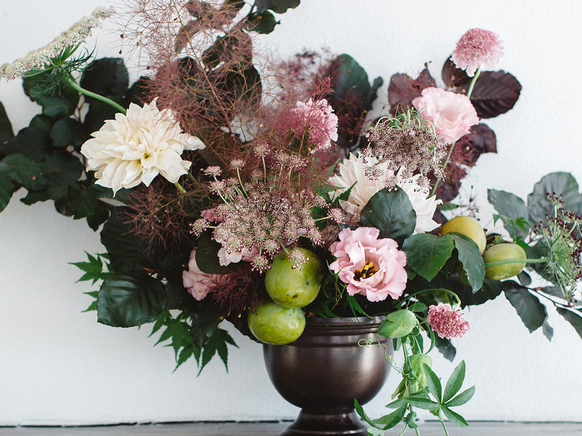  A floral arrangement sitting on top of a fireplace.