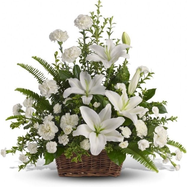 Elegant all-white funeral basket with lilies, carnations, lush greens, and fern fronds.