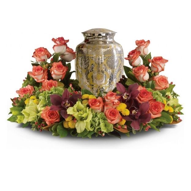 Elegant urn arrangement features a stunning combination of orange roses, lush green hydrangea, and rich, dark cymbidium orchids