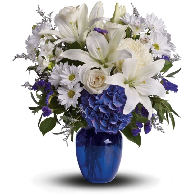 Elegant Father&rsquo;s Day flower arrangement with white lilies, roses, and blue hydrangeas in a deep blue glass vase.