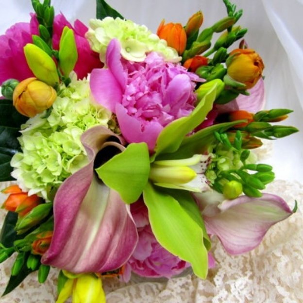 Bright summer wedding bouquet featuring pink peonies, calla lily, hydrangea, and seasonal blooms.