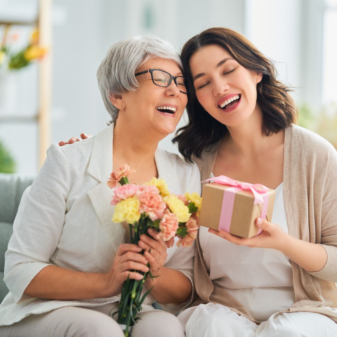 Adult child giving her mom a bouquet of flowers