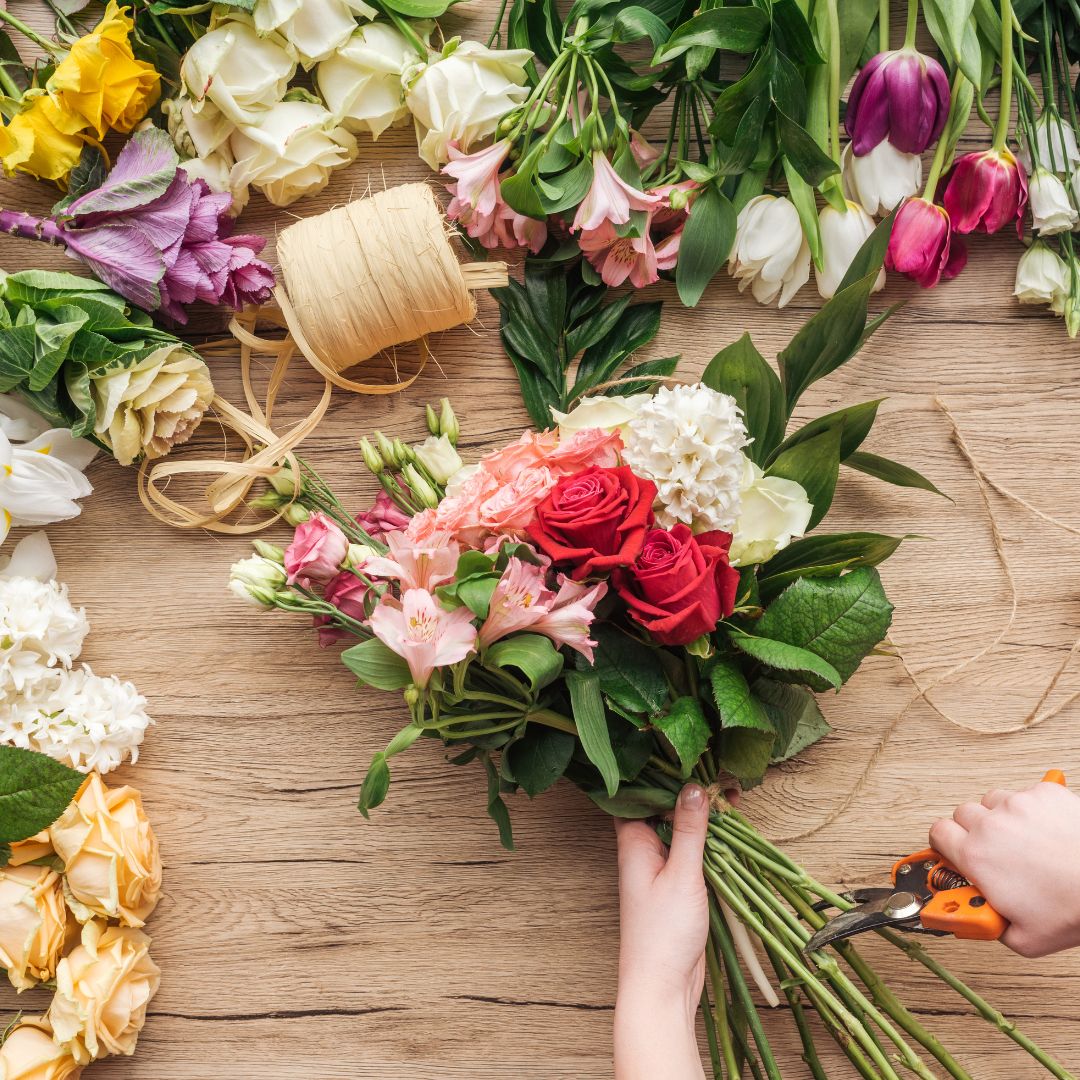 florist using event flowers for other arrangements