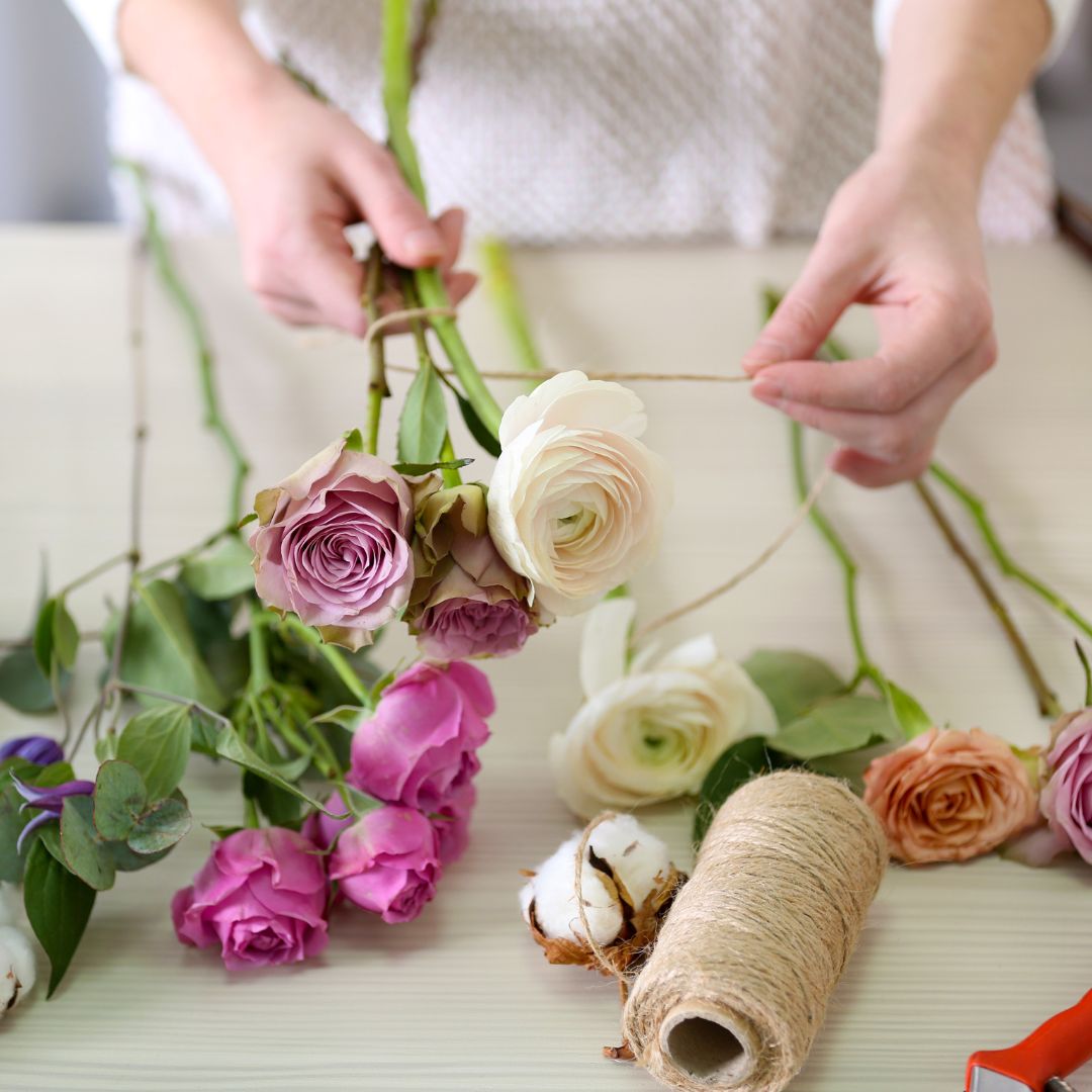 florist creating flower arrangement with roses